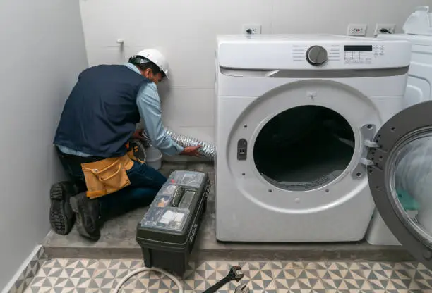 Reparación de lavadoras; un técnico haciendo la revisión de un electrodoméstico